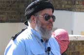 Abu Hamza, an ex nightclub bouncer from Soho holds a sermon outside Finsbury Park Mosque prior to leading Friday prayers. 

By many Muslims, Abu Hamza is regarded as being too extreme in his views. Here he can be seen being shadowed by one of his young guards as he publicly praises Bin Laden and criticises America.